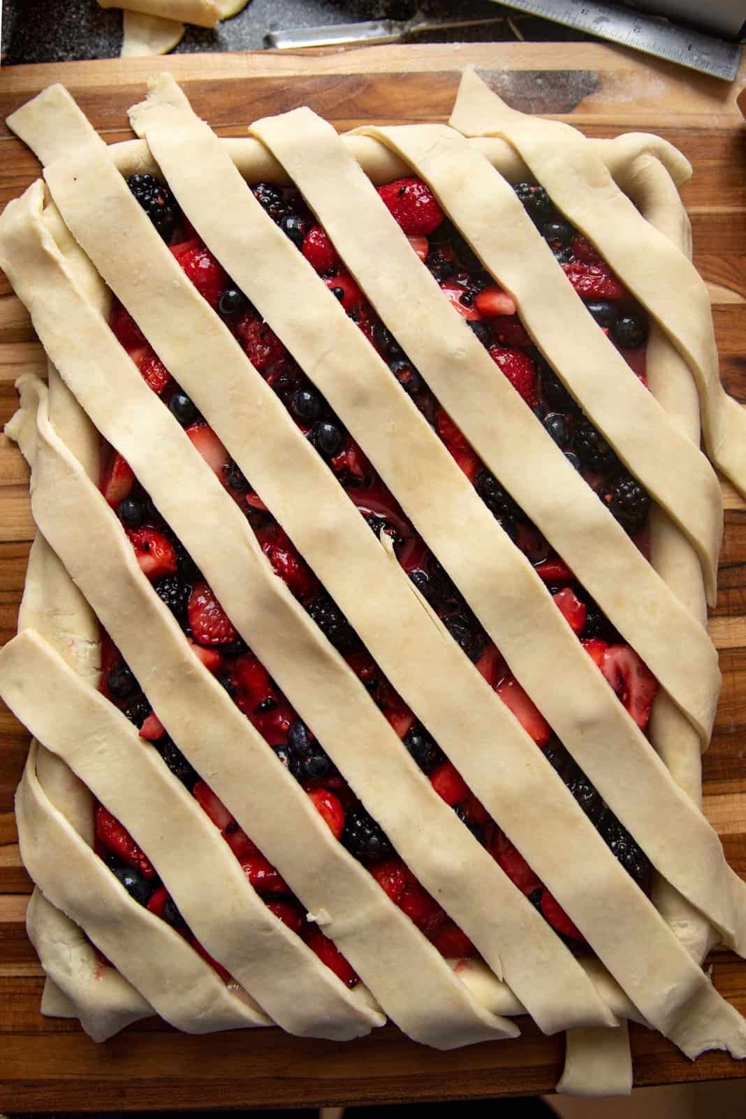 An overhead view of a partially completed lattice crust, with crust placed in one direction.
