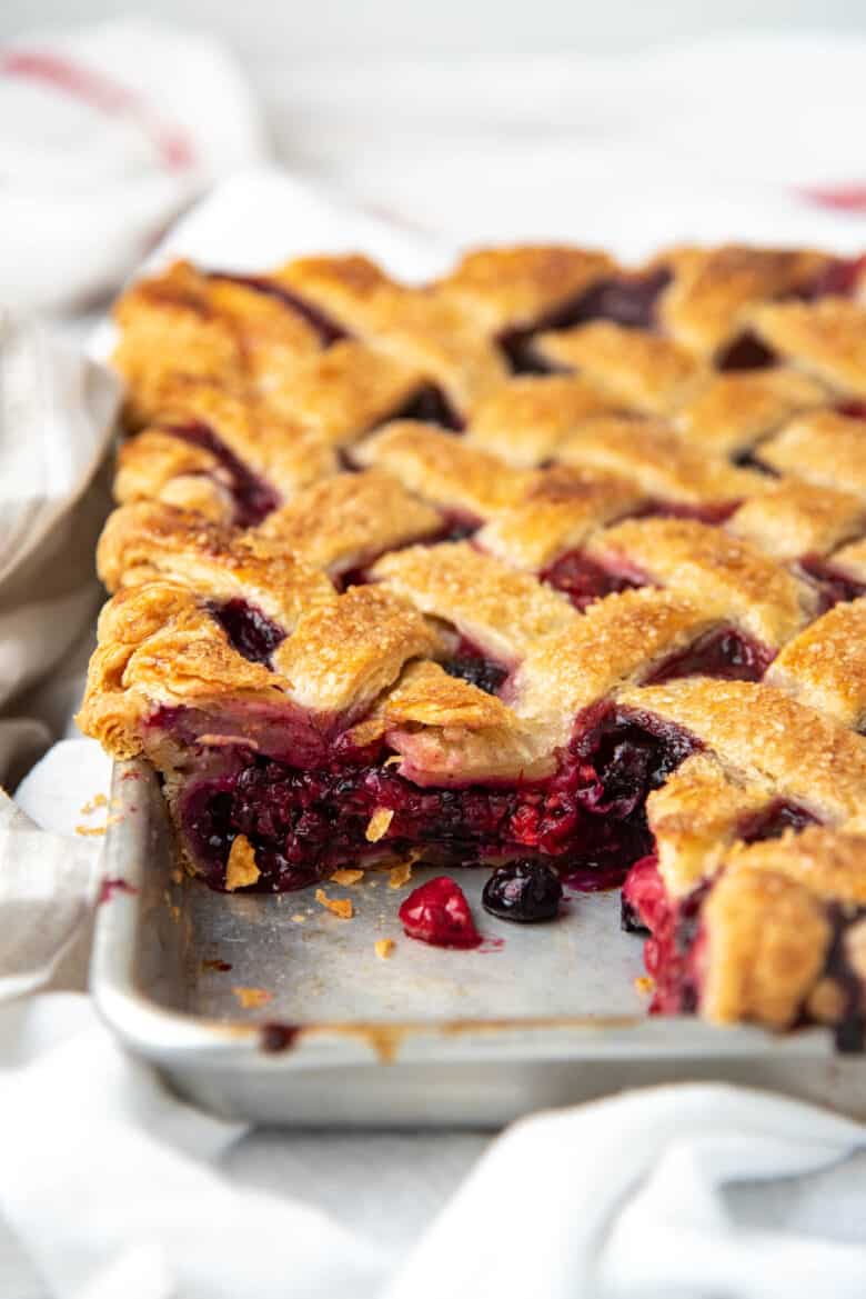 An angled view of the berry pie after a slice has been cut.