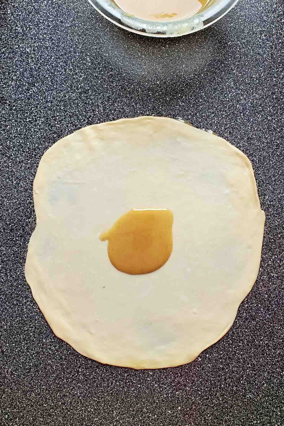 A spoonful of flour and oil paste placed in the middle of the rolled out dough.