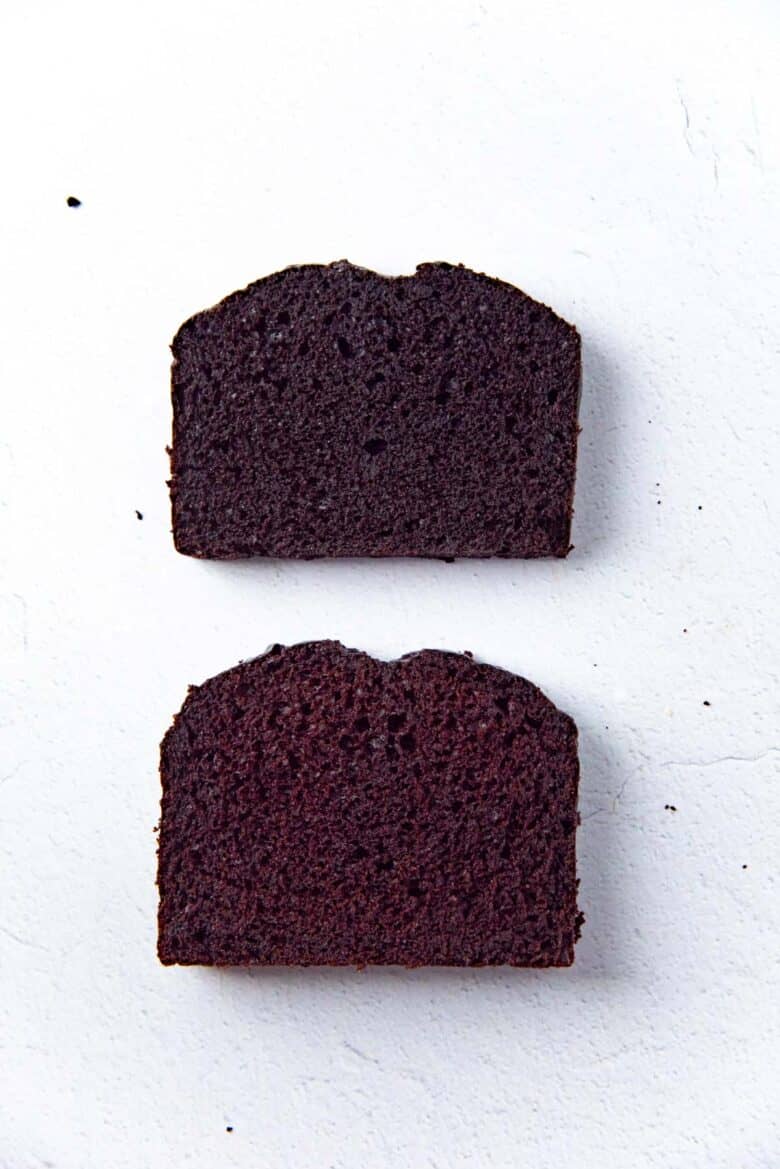 Two slices of chocolate cakes, laid on their side on a white surface, to show the difference in colors.