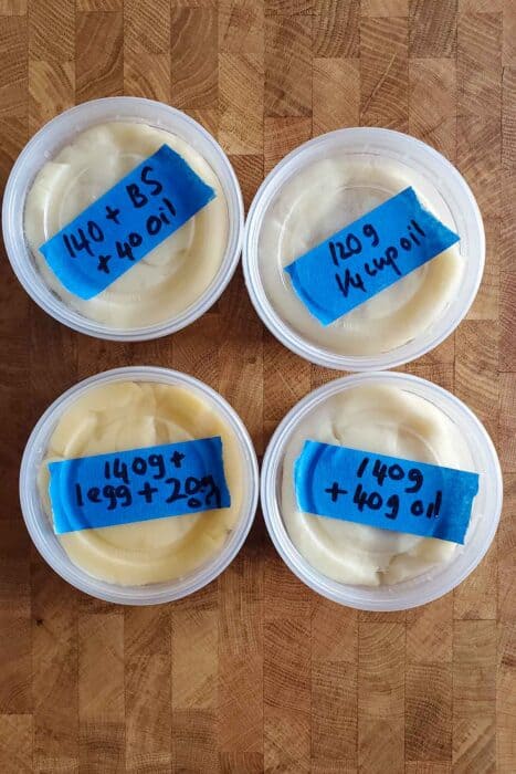 Four types of churros dough in plastic deli cups with labels on top of each cup.