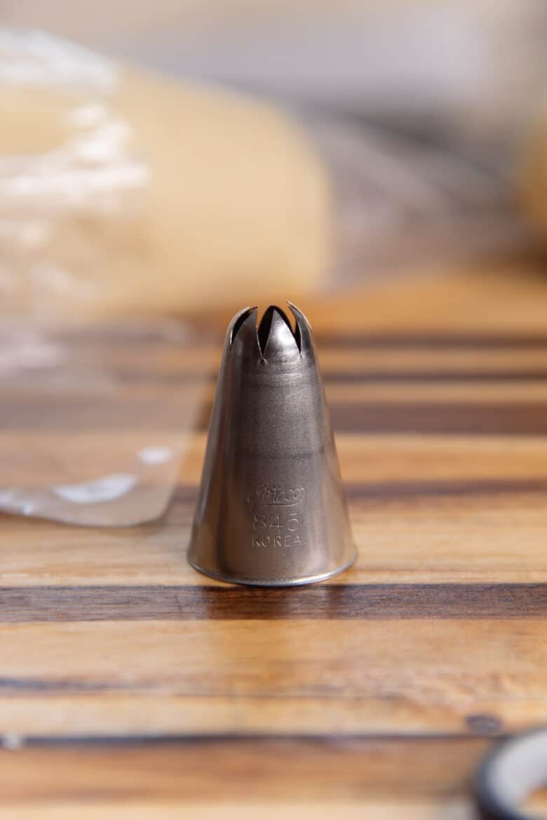 A close up of a closed star tip that is used to pipe out the churros.