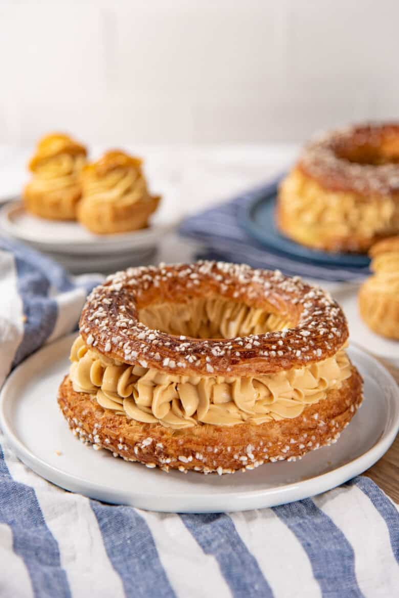 A single paris brest with the praline mousseline cream filling, served on a plate.
