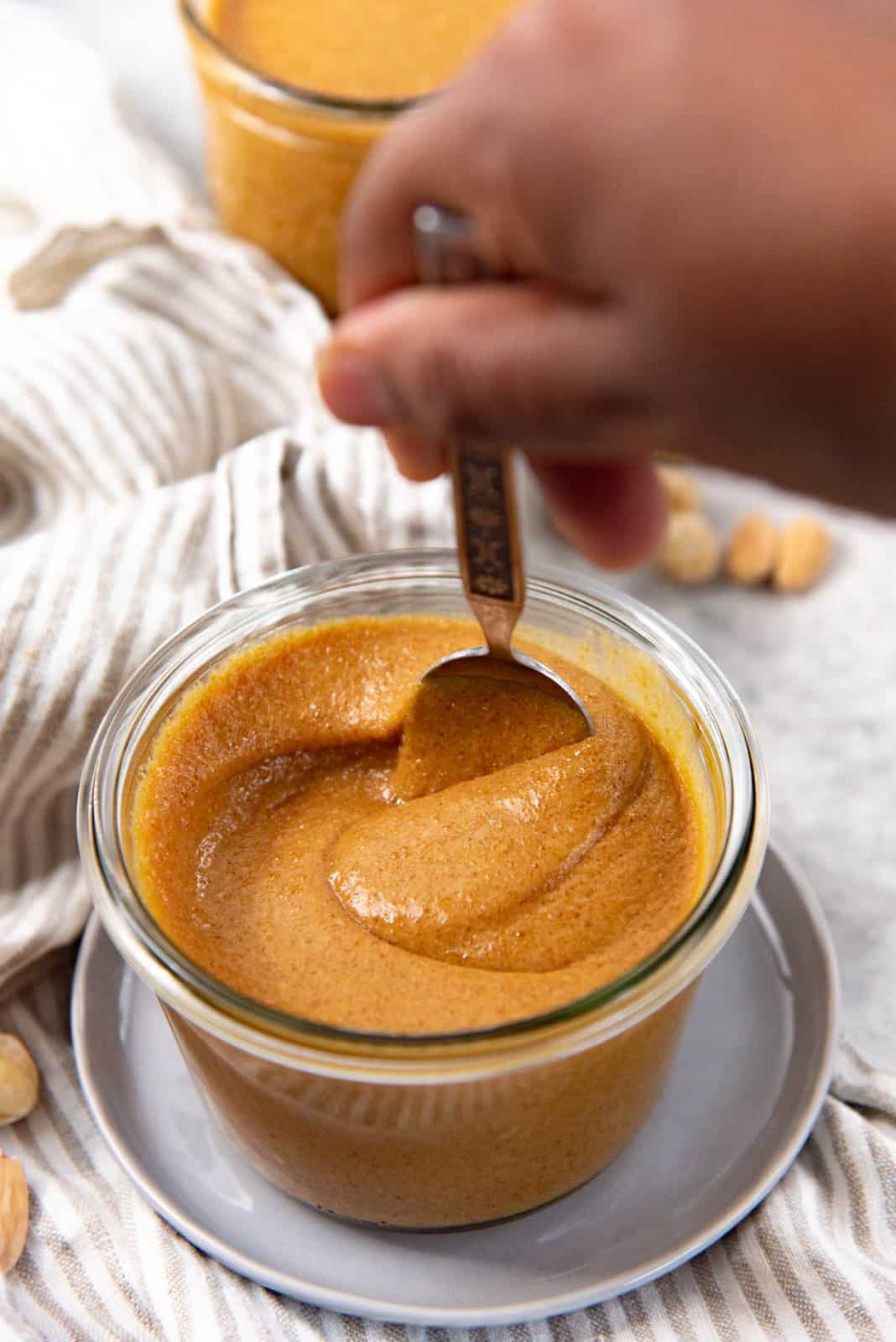 A still image of the praline paste, with a spoon stirring the praline paste to show the texture of the paste. 