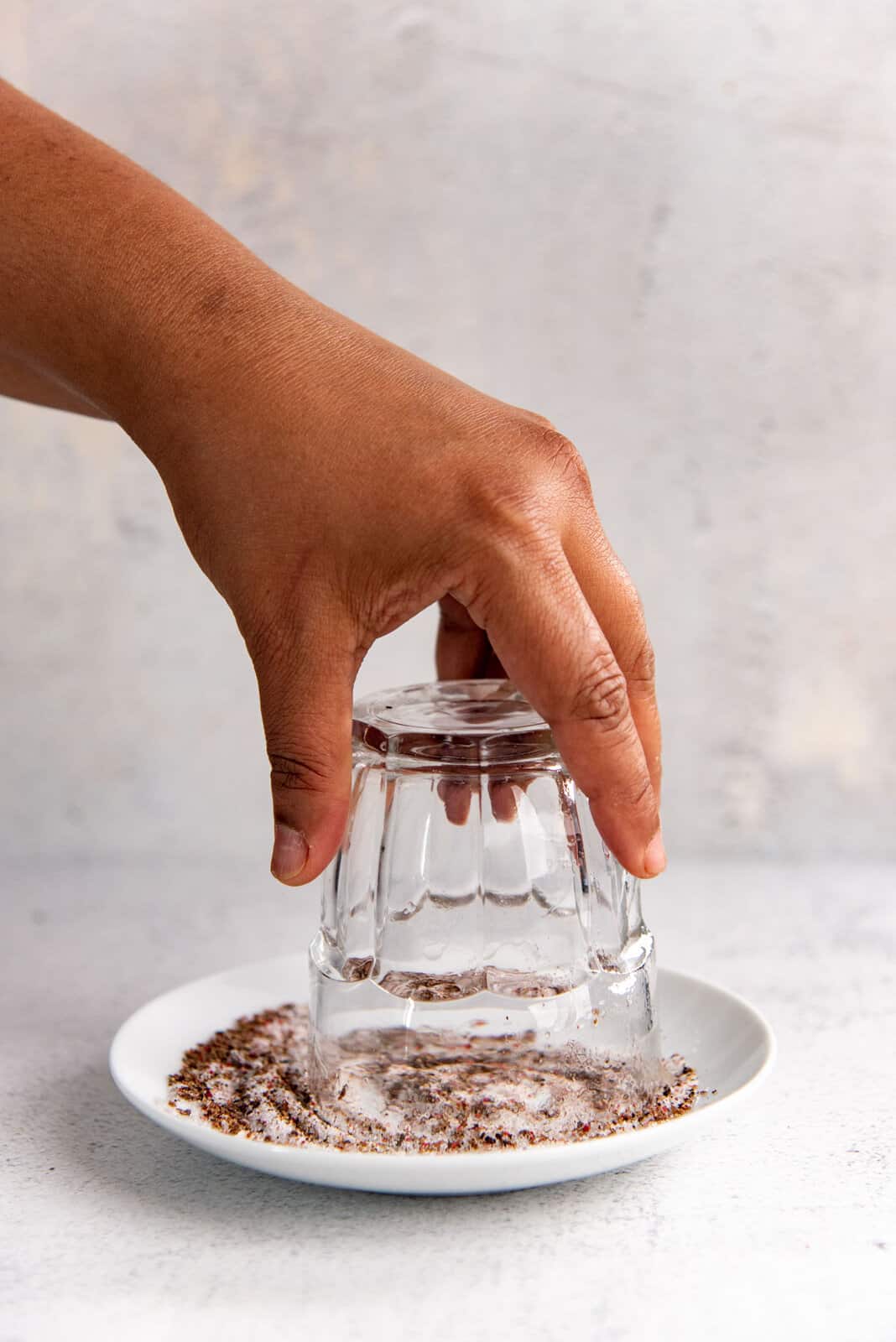 A glass turned upside down and placed on the salt and pepper mix to salt the rim of the glass.