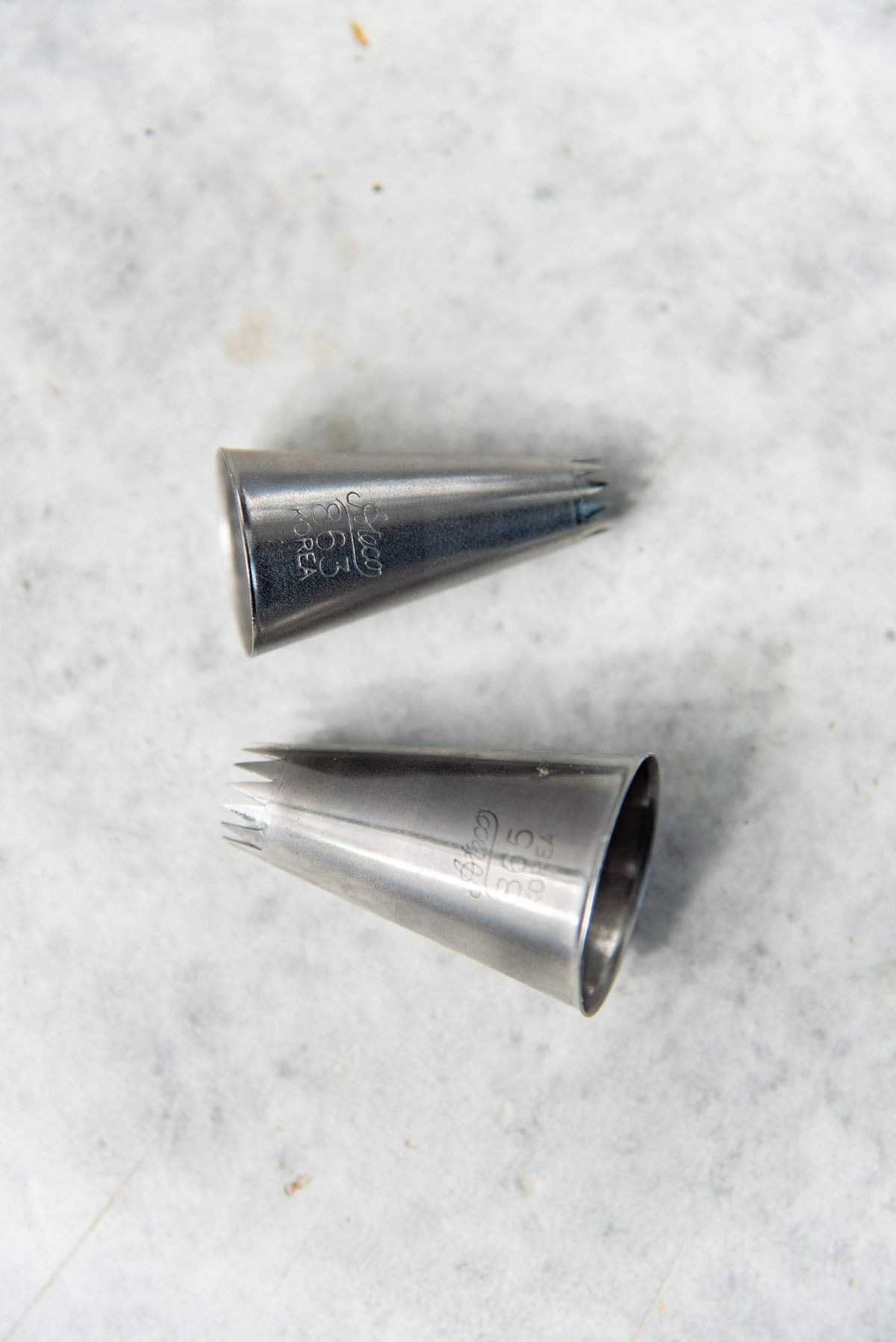 Two french star piping tips with different sizes. 