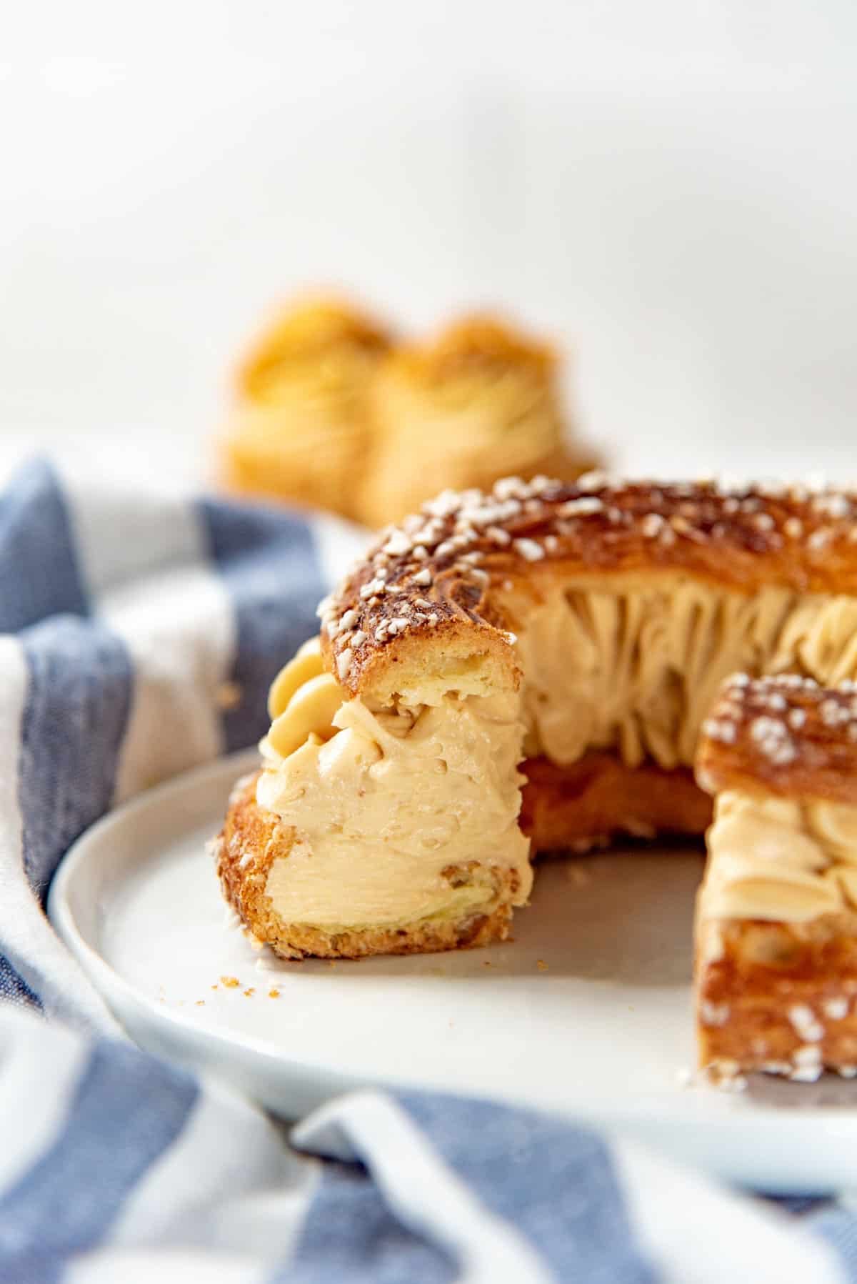A cross section of a Paris Brest pastry, showing the choux pastry and the praline mousseline cream filling.