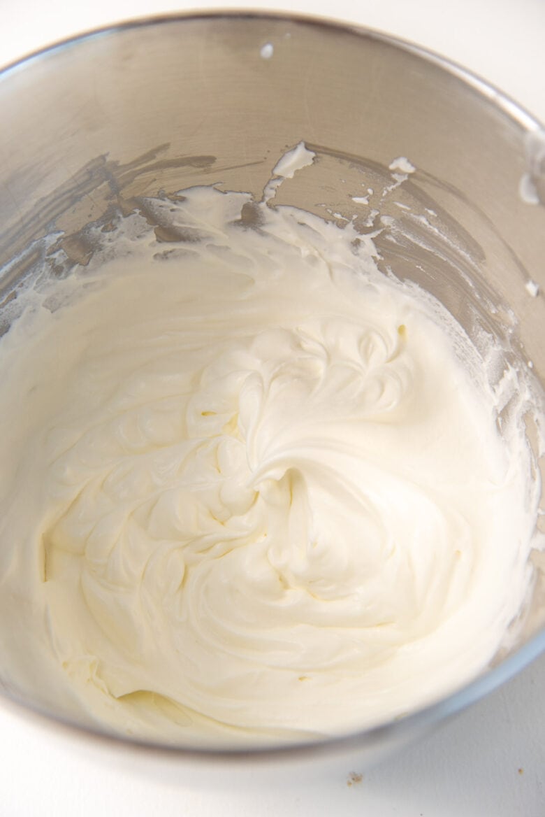 Whipped heavy cream inside a mixing bowl.