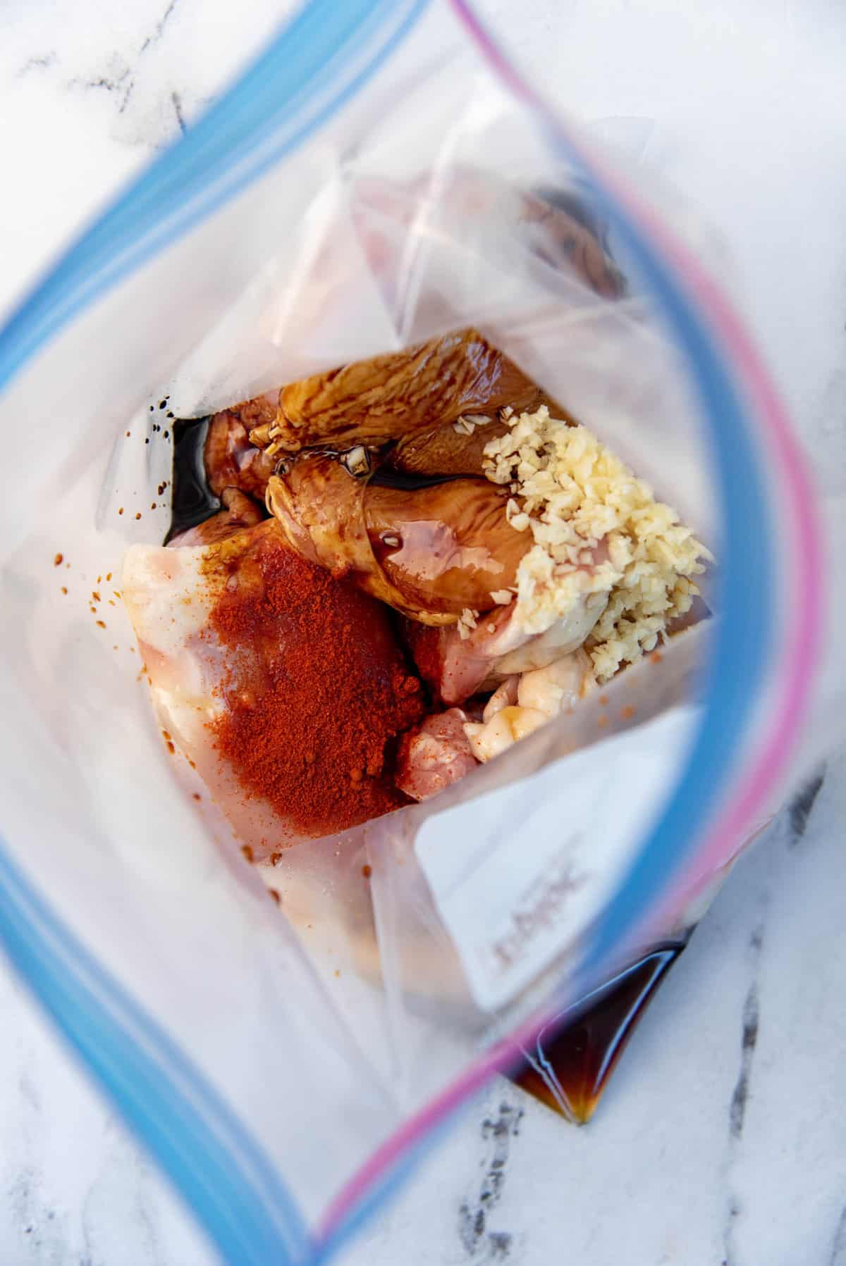 Chicken thighs in a freezer ziploc bag with marinate ingredients added to it.