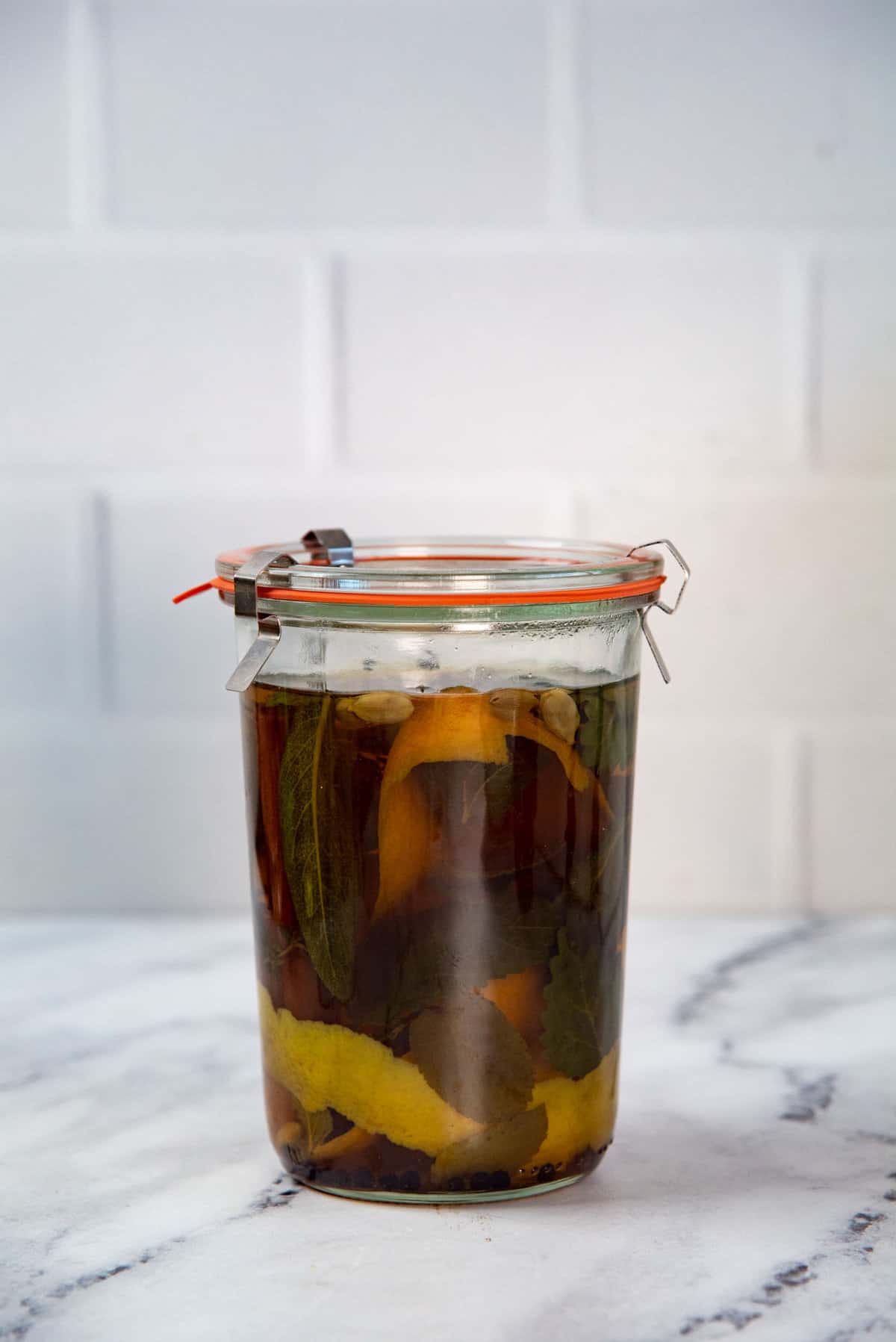 Gin infused with herbs and spices in a tall weck jar.