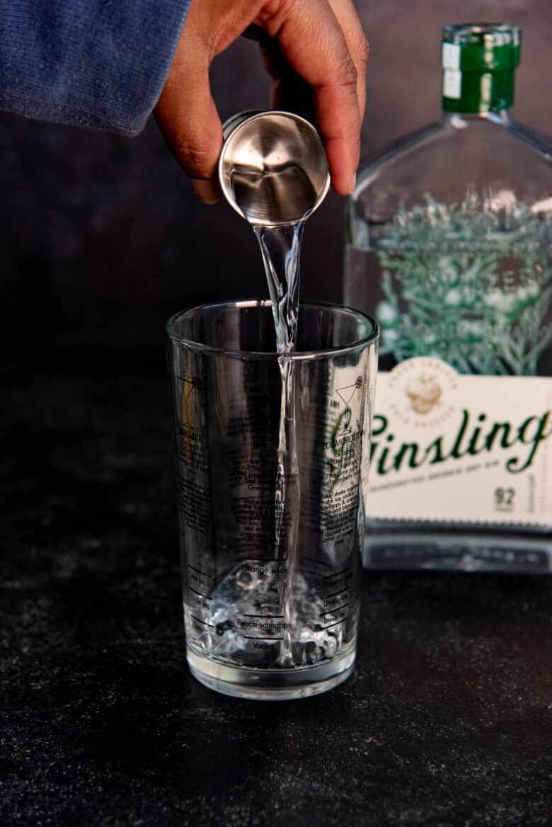 Gin being poured into a cocktail shaker glass.