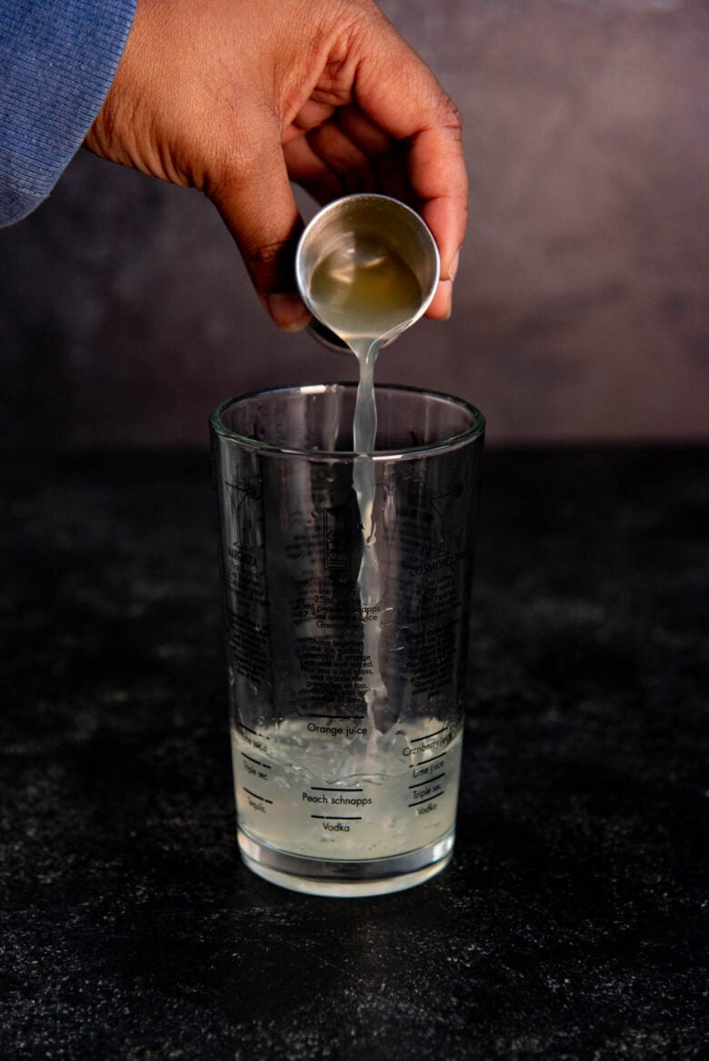 Lemon juice being poured into the cocktail shaker glass.