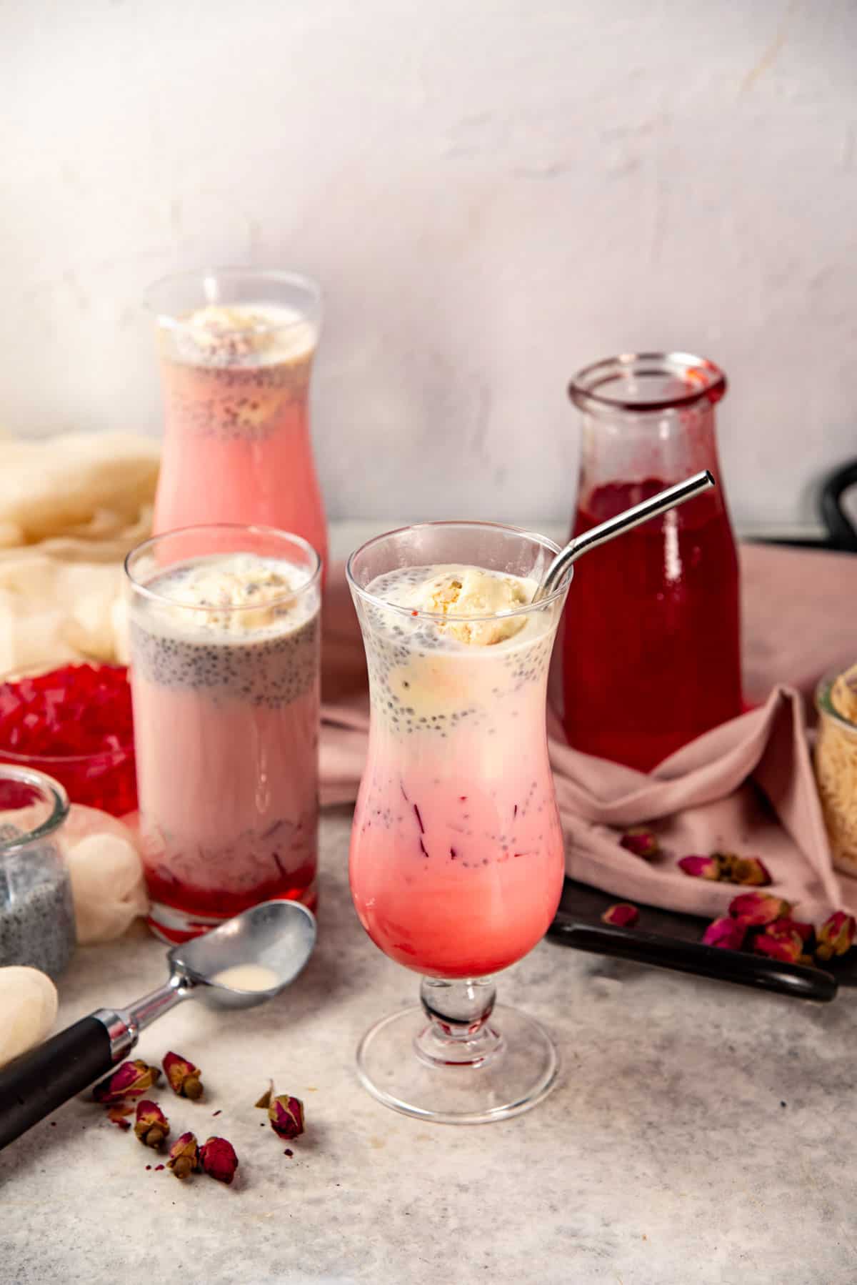 Three glasses of pink drinks made with rose syrup and rose water.