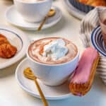French hot chocolate (Chocolat Chaud) served with whipped cream on top and an eclair on the side.