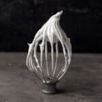 Swiss meringue with stiff peaks on a whisk.