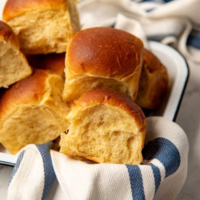 A white tray of stacked Hawaiian bread rolls.