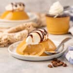 Coffee panna cotta on a plate with a scoop taken out to show creamy consistency.