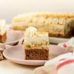 Banana pudding cake piece showing banana cake and banana pudding layers topped with whipped cream.