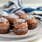 Chocolate choux pastry with chocolate cream filling on a gray serving platter.