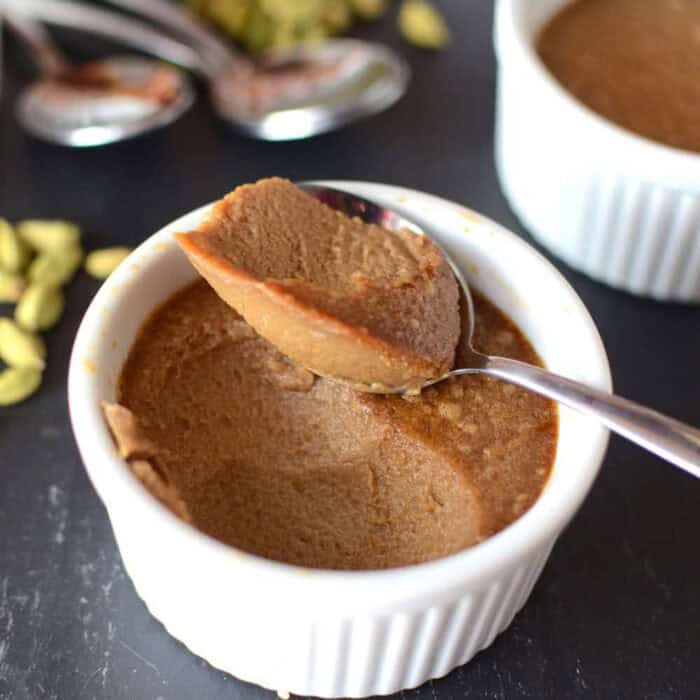 Sri Lankan watalappan pudding served in a small white ramekin with a spoonful taken out to show the creamy consistency.