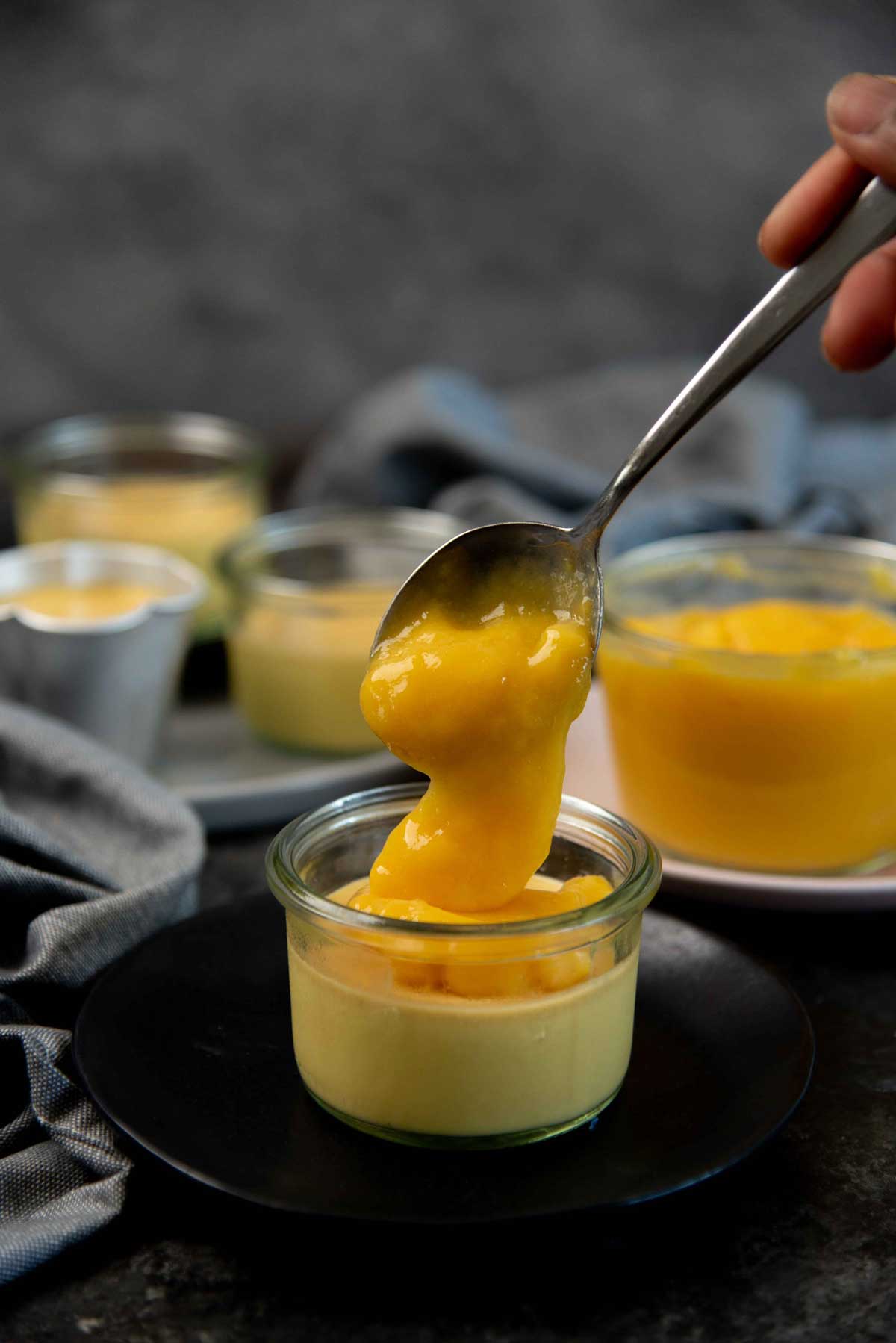 Dolloping mango gel over mango panna cotta set in a small glass dish.