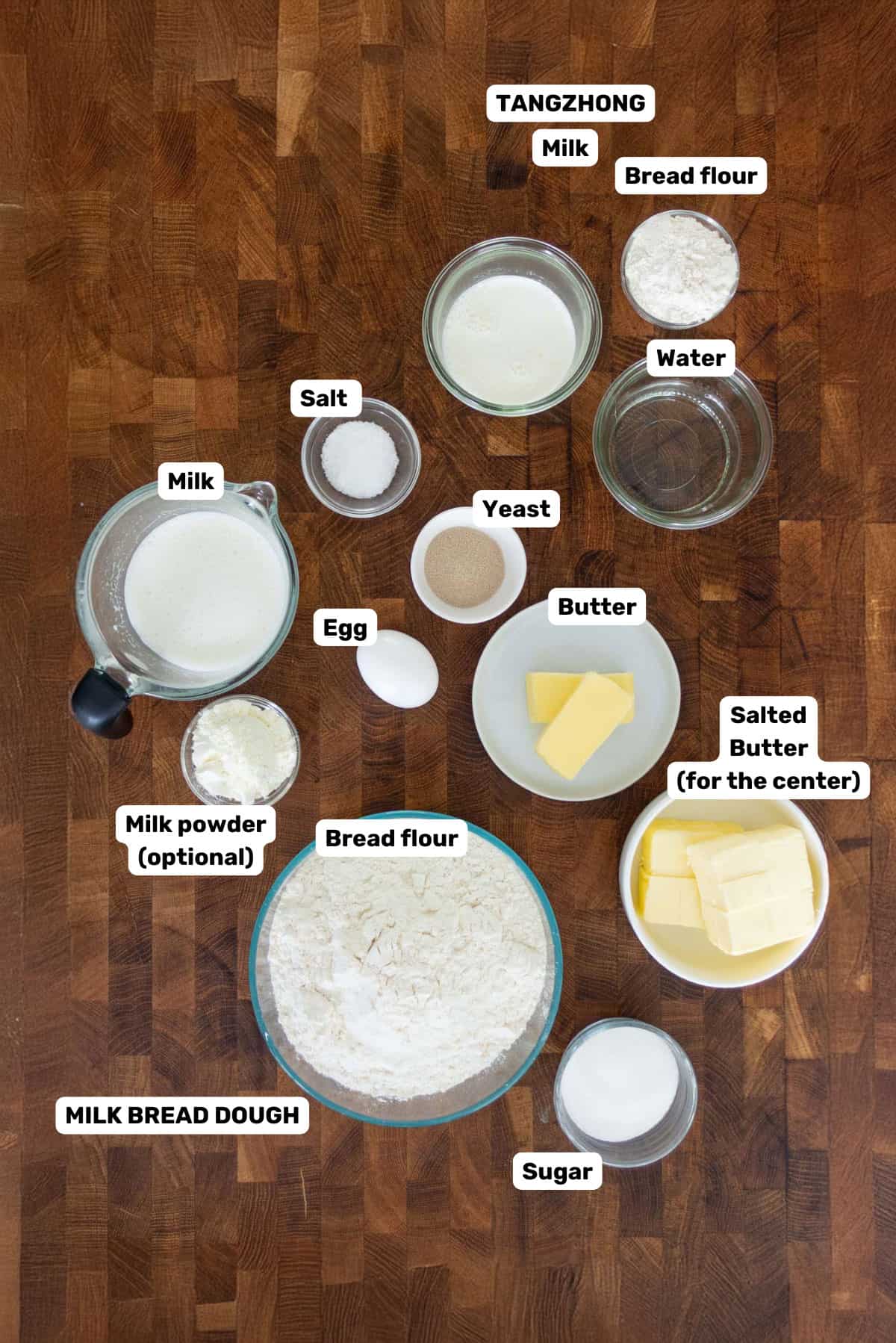 Labeled ingredients to make salt bread on a wooden surface.