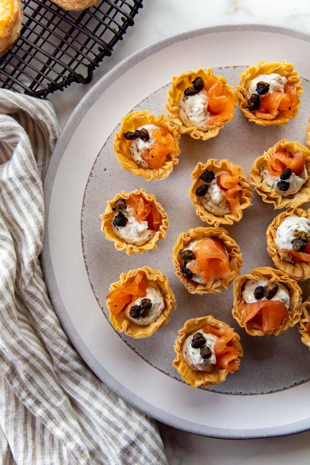Overhead view of smoked salmon appetizers on a plate served in mini phyllo cups.