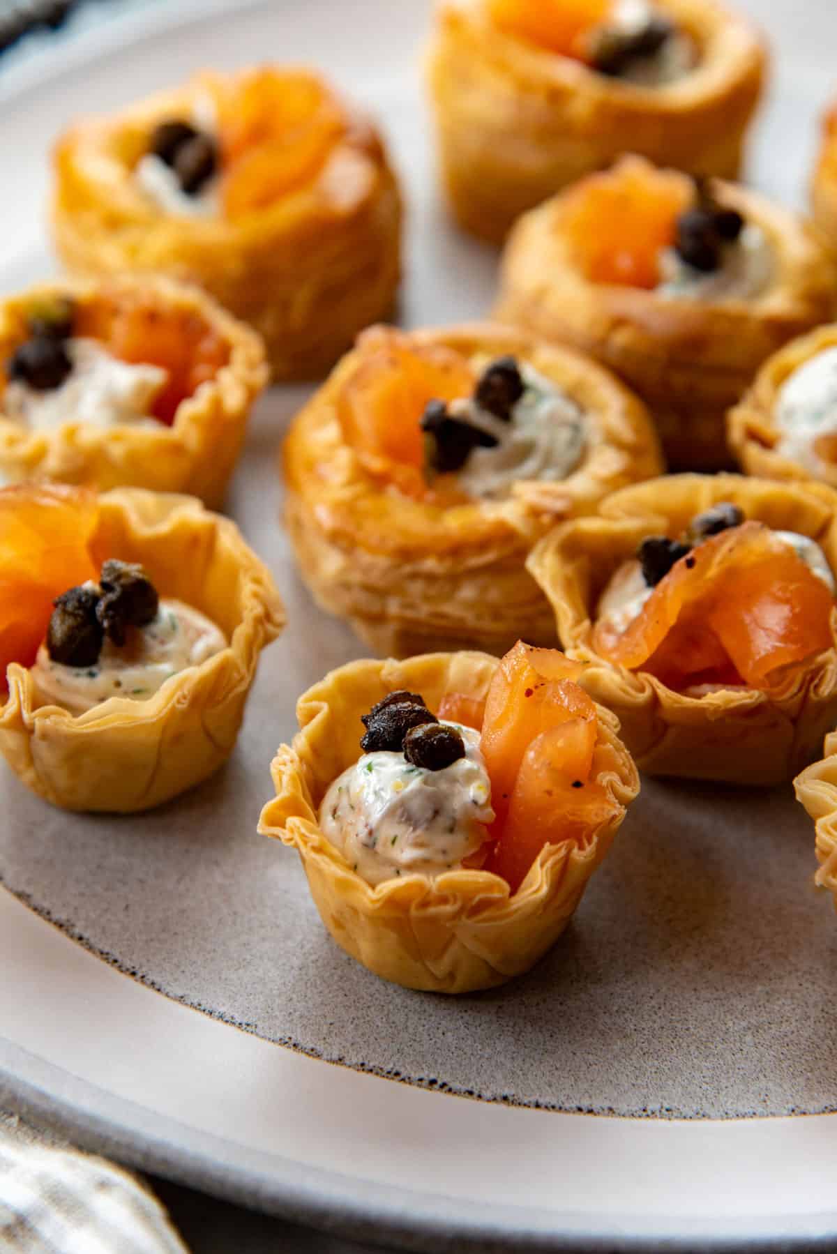 Close up of the smoked salmon canapes showing the cream cheese filling with chopped herbs and smoked salmon slices.