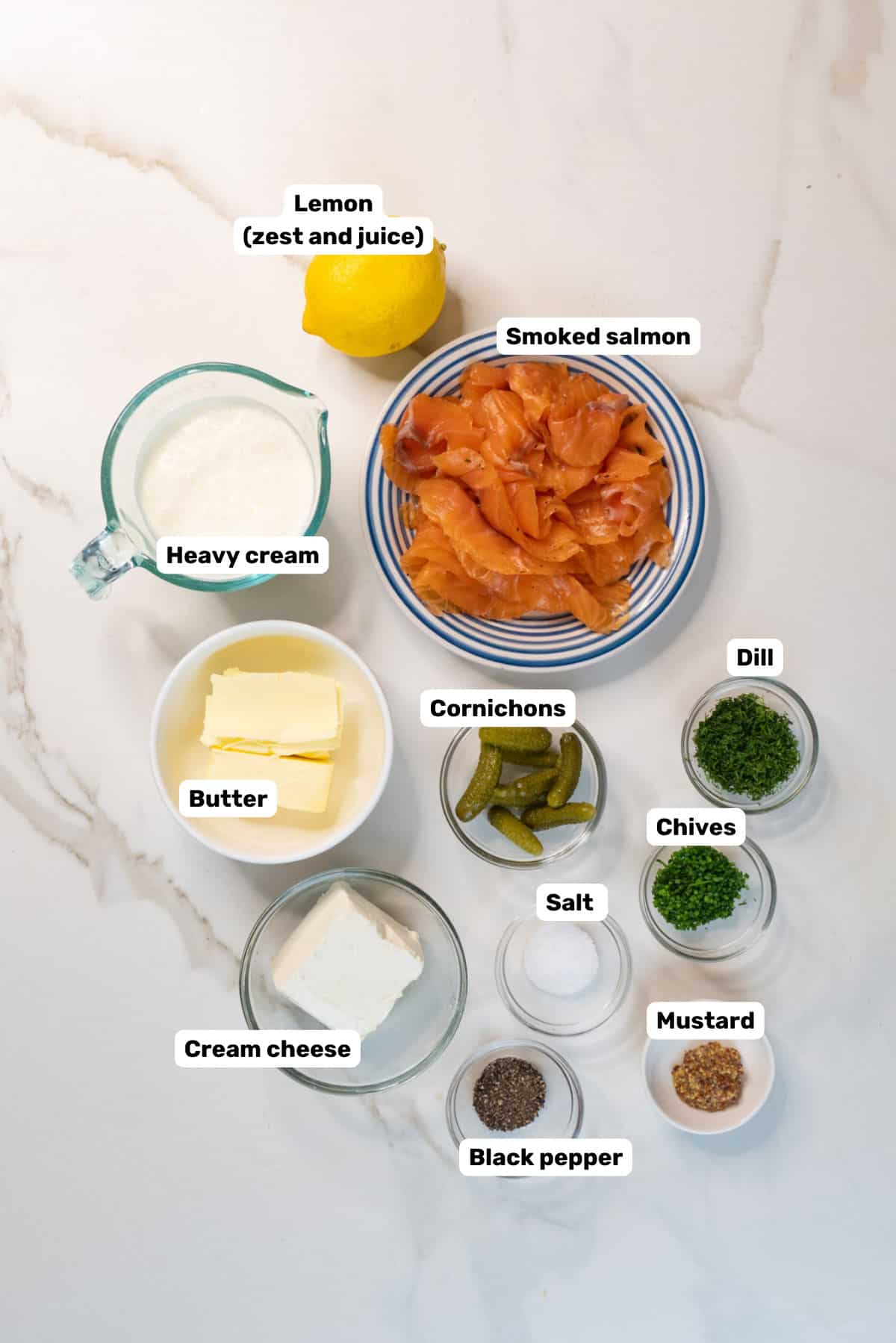 Labeled ingredients to make smoked salmon mousse on a white counter.