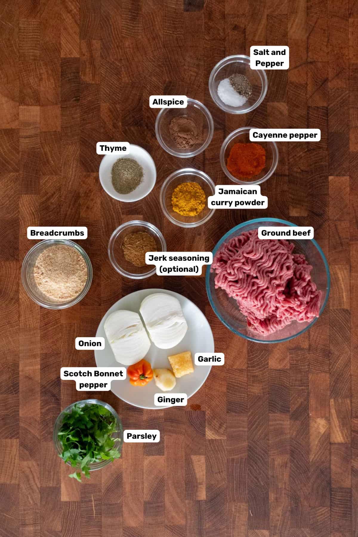 Labeled ingredients to make the spicy curried beef filling on a wooden surface.