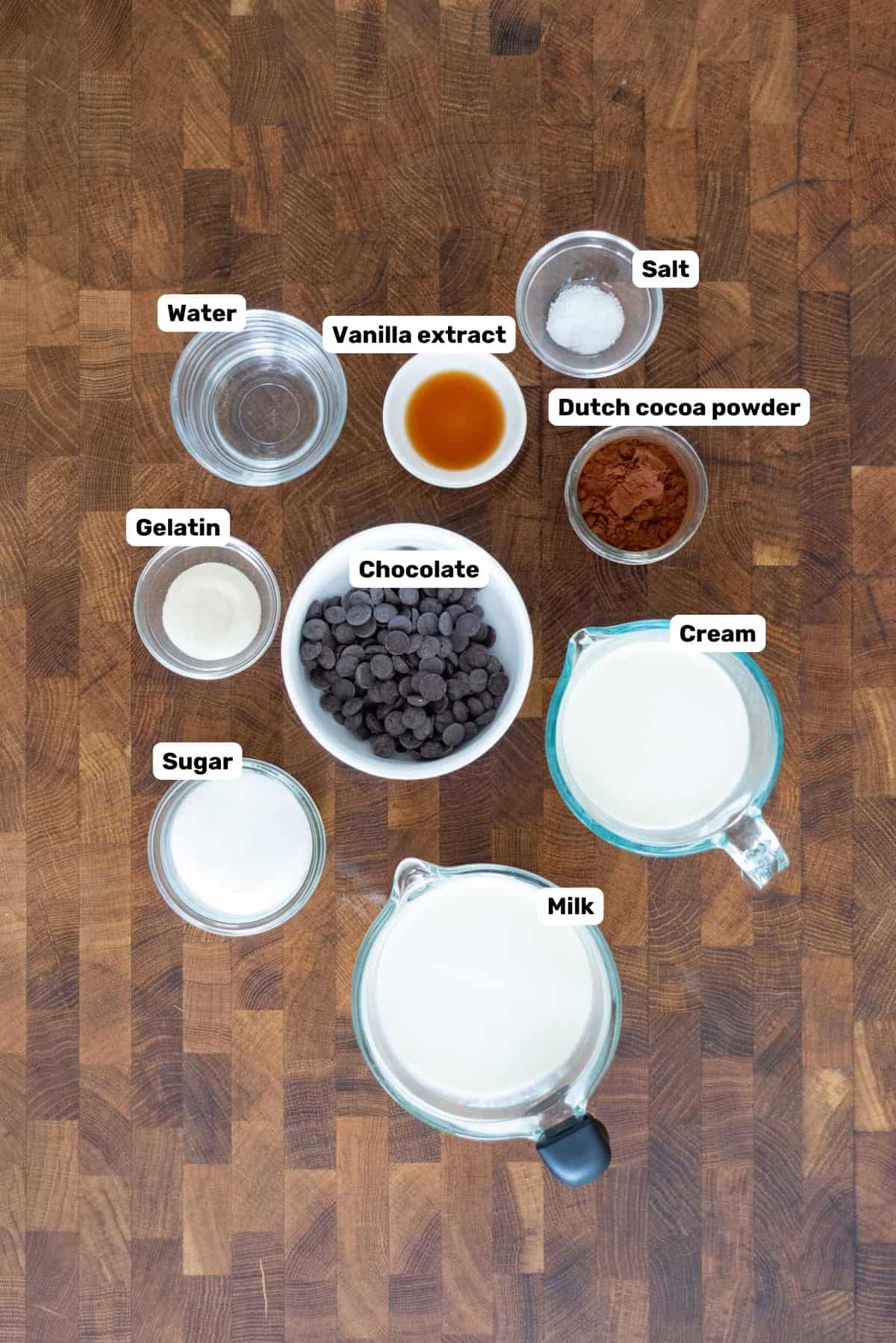 Labeled ingredients to make fudgesicles on a wooden surface.